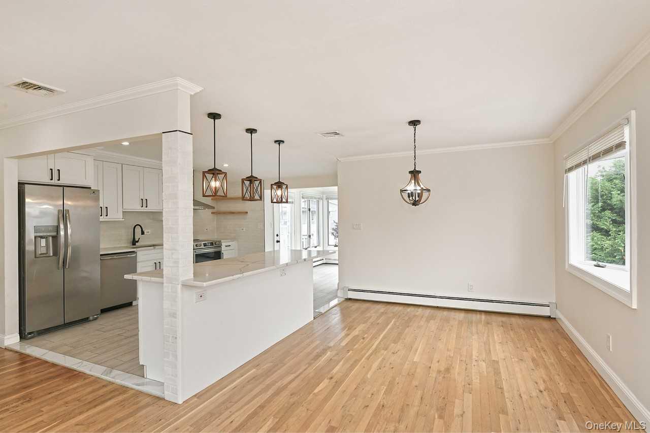 107 Beverly Road Massapequa, NY 11758 - Photo 11 of 41 a kitchen with stainless steel appliances a refrigerator and a stove top oven