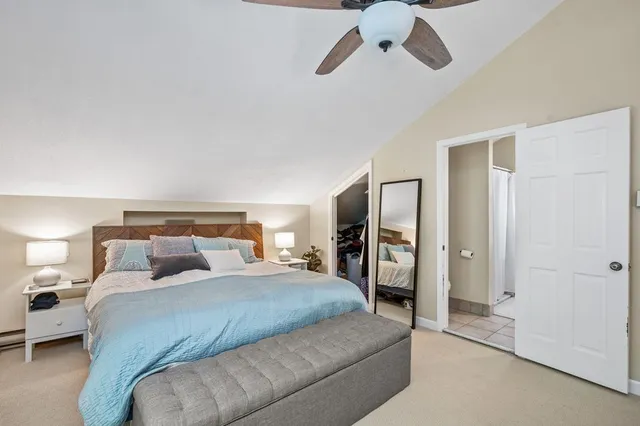a bedroom with a large bed and a chandelier