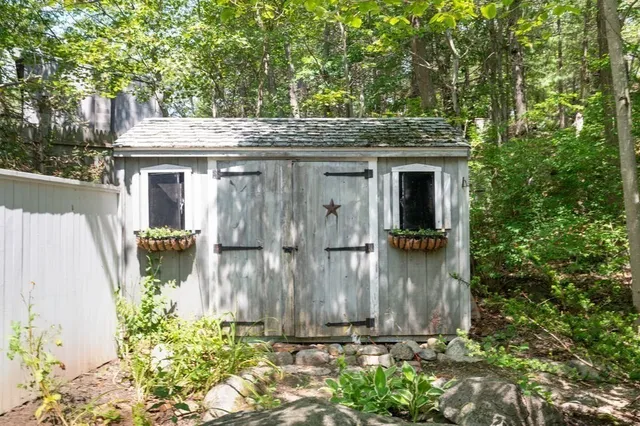 a view of a wooden house with a small yard and plants