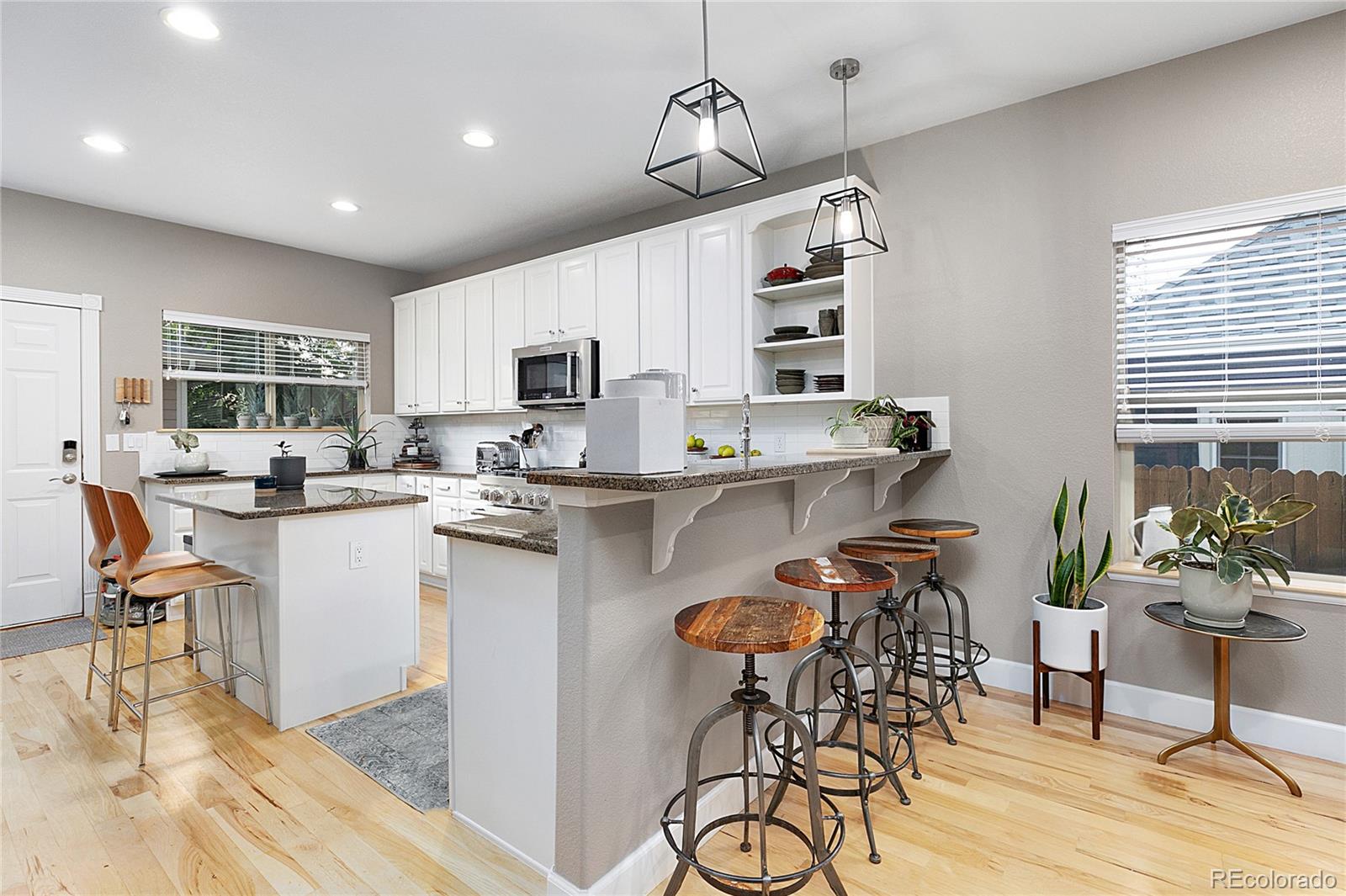 4511 Perry Street Denver, CO 80212 - Photo 8 of 36 a kitchen with a table chairs microwave and cabinets