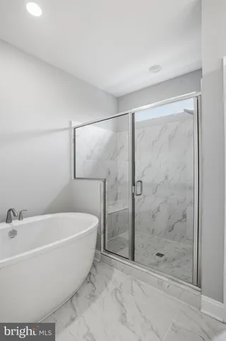 a white bath tub sitting next to a shower