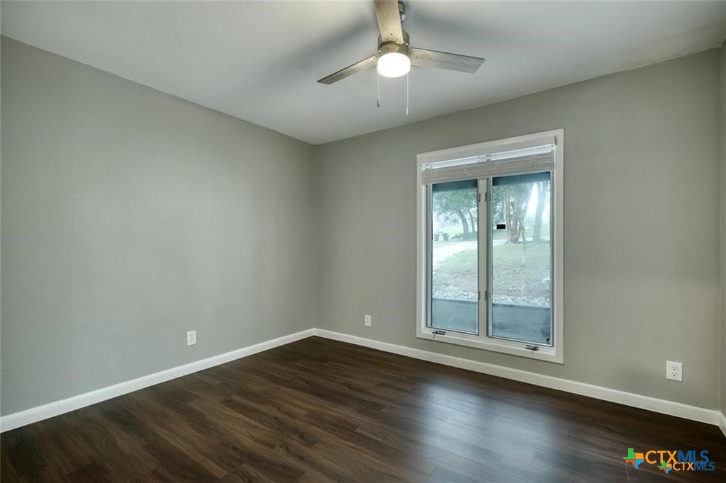 1529 North Colorado Street Lockhart, TX 78644 - Photo 12 of 14 Third bedroom with ceiling fan, hard surface flooring and window for natural light