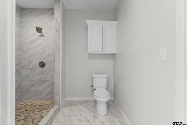 a white toilet sitting next to a bathroom sink