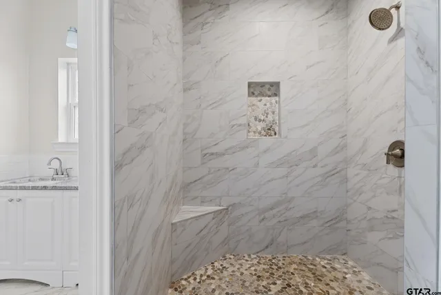 a bathroom with a granite countertop shower