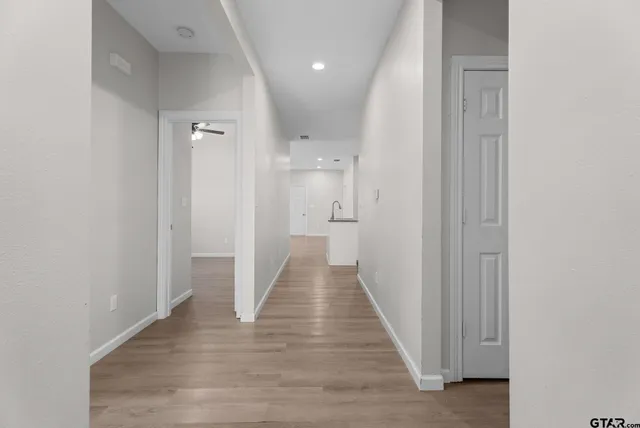 a view of a hallway with wooden floor