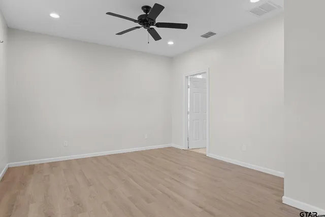 a view of a big room with wooden floor and windows in a room
