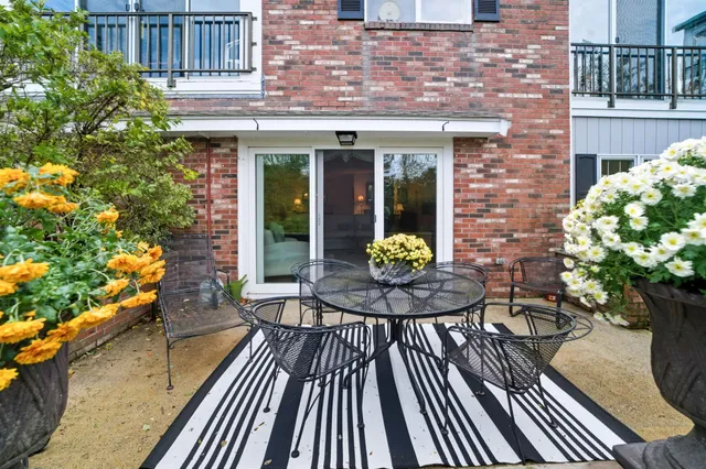 a view of a house with a chairs and table in a patio