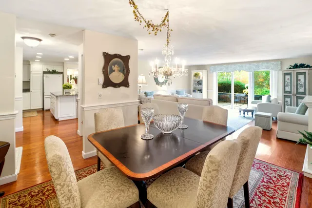 a living room with furniture a large window and dining table