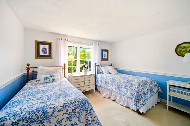 a bedroom with a bed a wall painting and a window