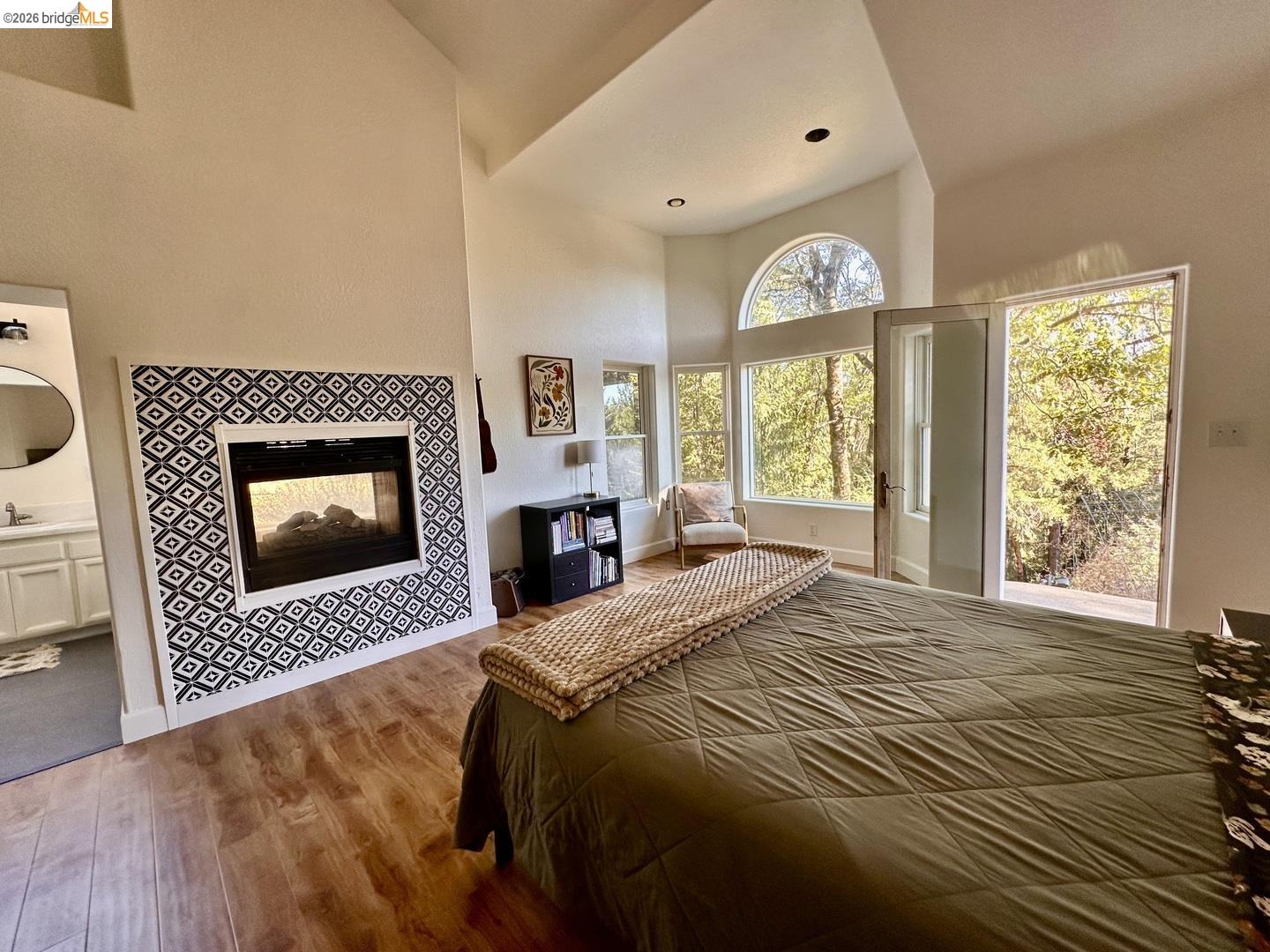 2080 Nelson Road Camino, CA 95709 - Photo 28 of 55 Vaulted ceilings, wood-finish flooring, a fireplace with decorative tile surround, large windows, and a glass-paneled door