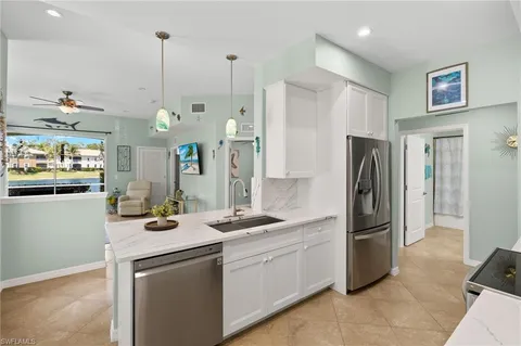 a kitchen with stainless steel appliances kitchen island granite countertop a refrigerator a oven a sink and a refrigerator