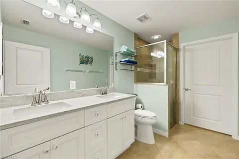 a spacious bathroom with a granite countertop sink a toilet and a mirror