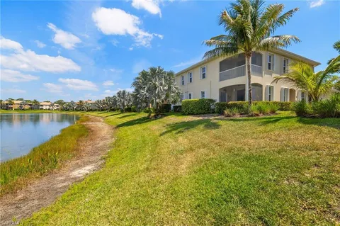 a front view of a house with a yard and lake view