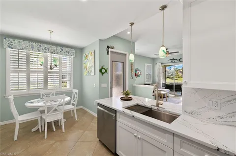 a kitchen with a sink and chairs