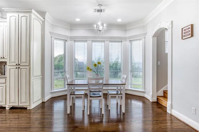 a dining room with wooden floor a chandelier