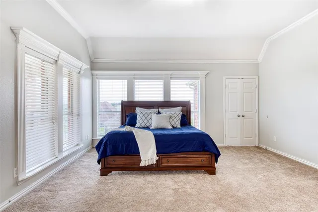 a spacious bedroom with a bed and large windows