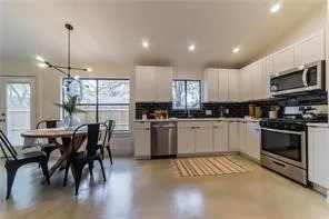 a kitchen with a table chairs microwave and cabinets