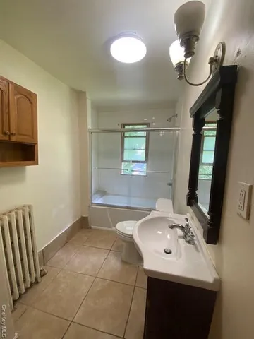 a bathroom with a sink a light fixture and a mirror