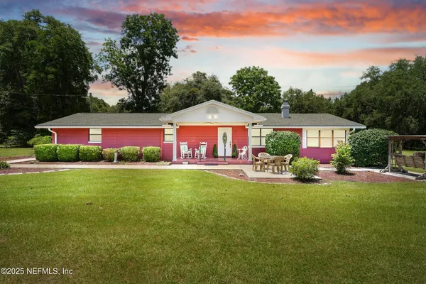 a front view of a house with yard and green space
