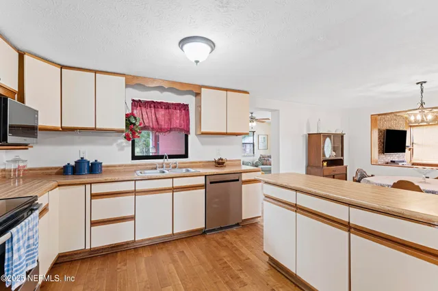 a kitchen with stainless steel appliances granite countertop a sink stove and cabinets