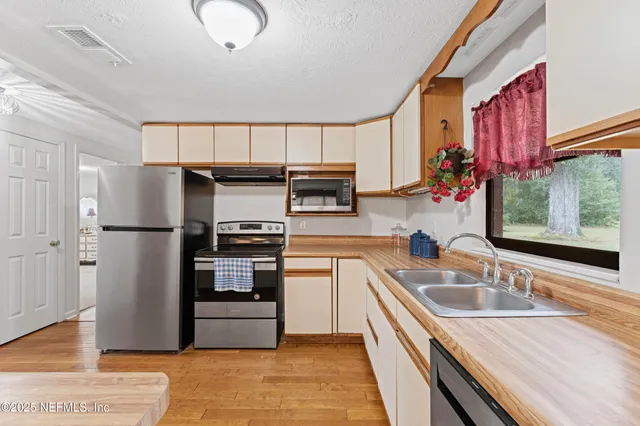 a kitchen with stainless steel appliances granite countertop a refrigerator and a sink