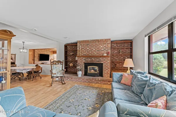 a living room with furniture large window and a fireplace