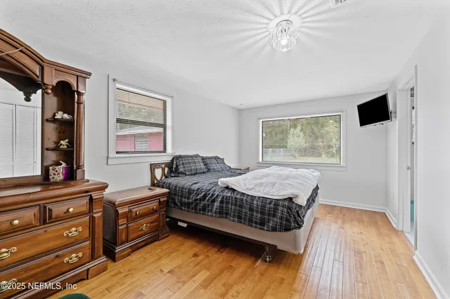 a bedroom with a bed dresser and a window