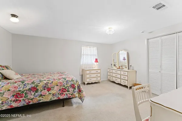 a bedroom with a white bed and dresser