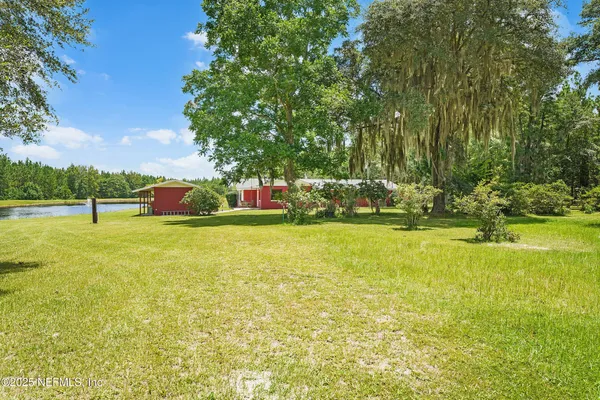 an aerial view of a house with swimming pool and large trees
