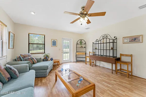 a living room with furniture a two window and a flat screen tv