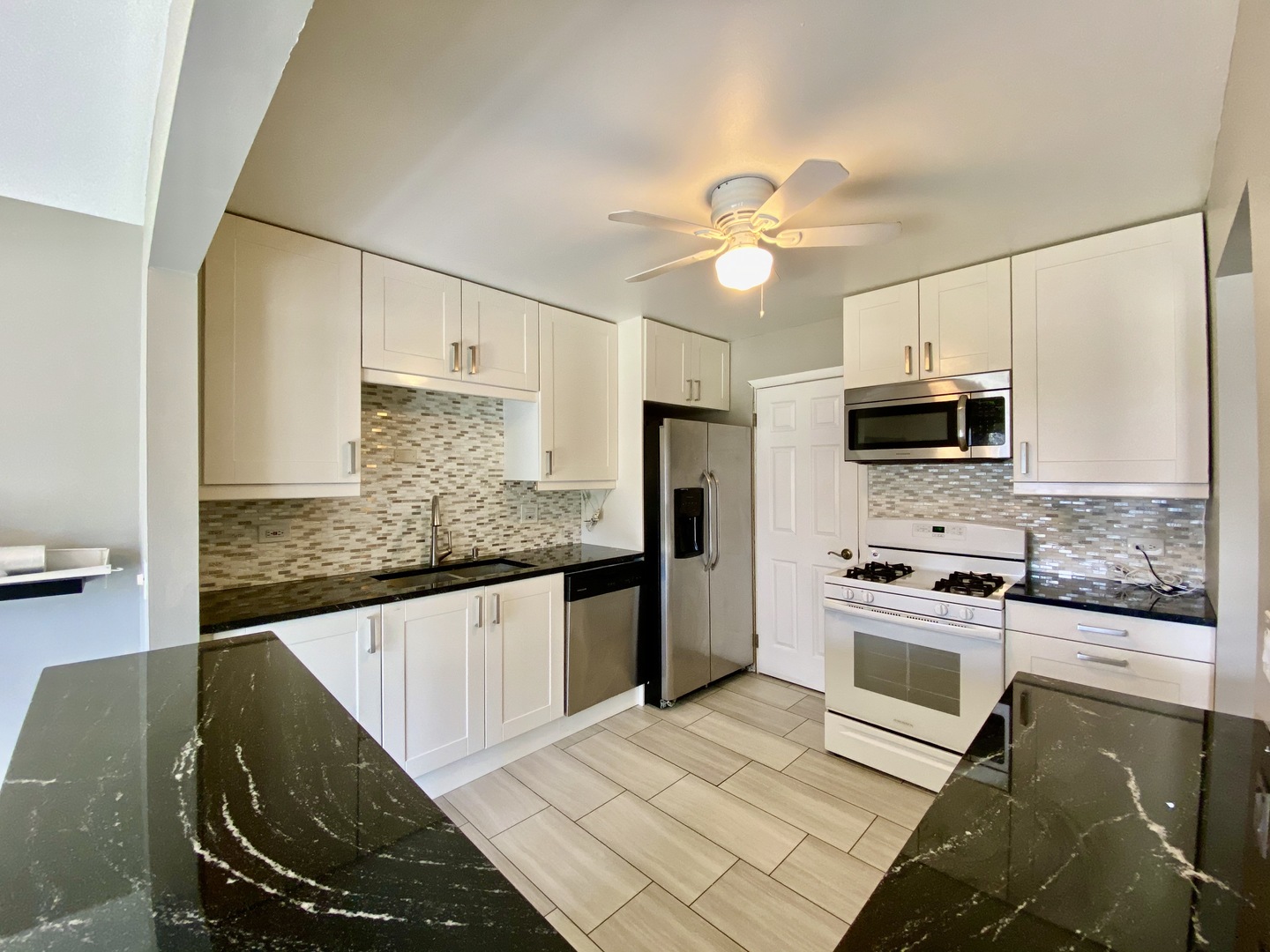 1115 Scanlon Drive, Unit B1 Wheeling, IL 60090 - Photo 3 of 12 a kitchen with stainless steel appliances granite countertop a sink a stove top oven a counter space and cabinets
