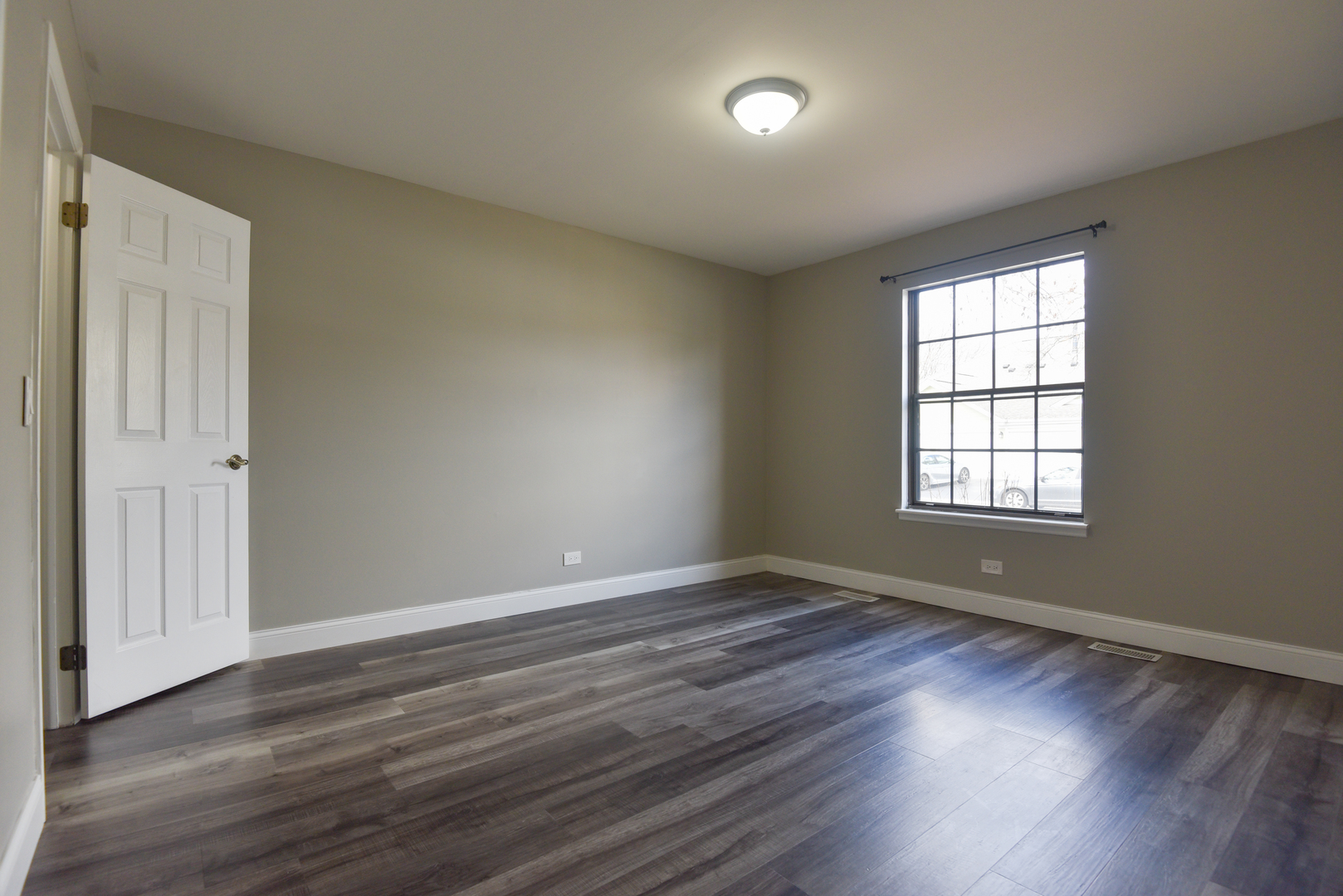 1115 Scanlon Drive, Unit B1 Wheeling, IL 60090 - Photo 8 of 12 a view of an empty room with wooden floor and a window