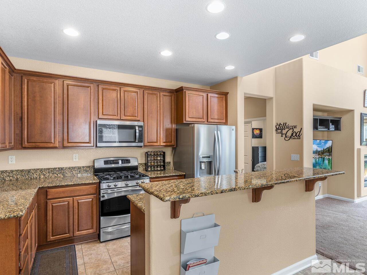515 Little Sorrel Court Reno, NV 89521 - Photo 8 of 26 a kitchen with stainless steel appliances granite countertop a stove refrigerator sink and cabinets