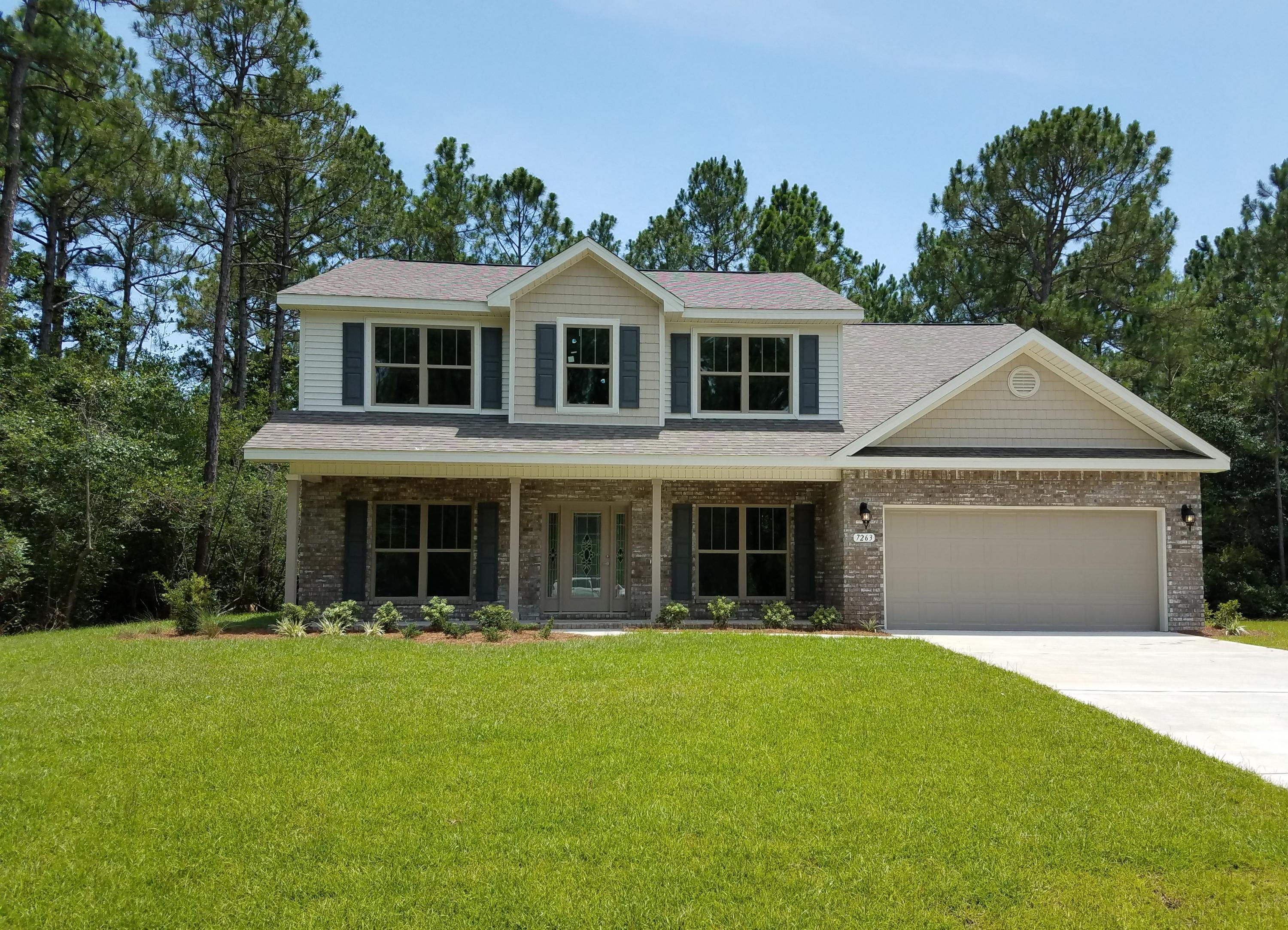 7263 Riverview Road Navarre, FL 32566 - Photo 1 of 8 a front view of a house with garden