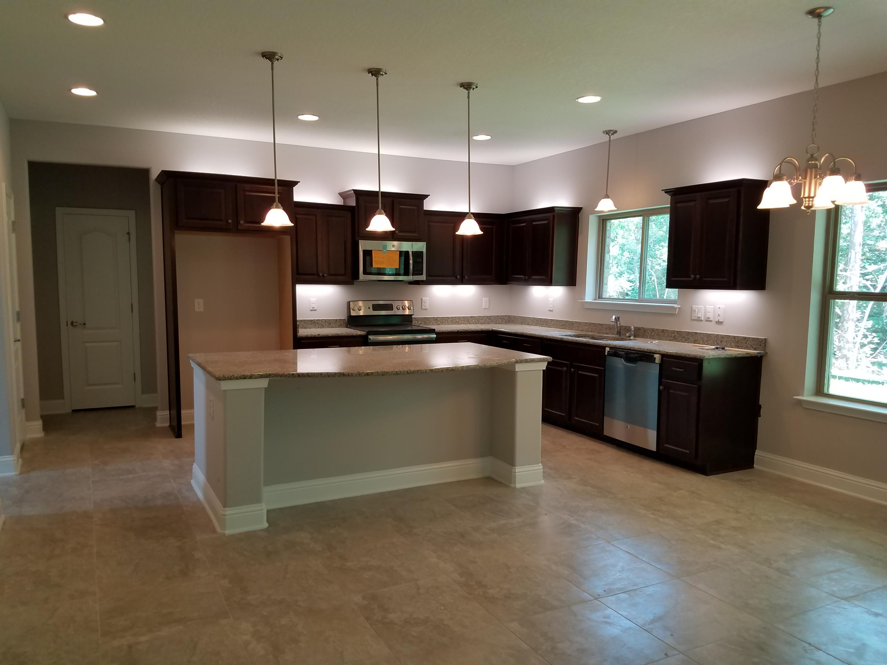 7263 Riverview Road Navarre, FL 32566 - Photo 3 of 8 a kitchen with stainless steel appliances granite countertop a stove a sink and a refrigerator