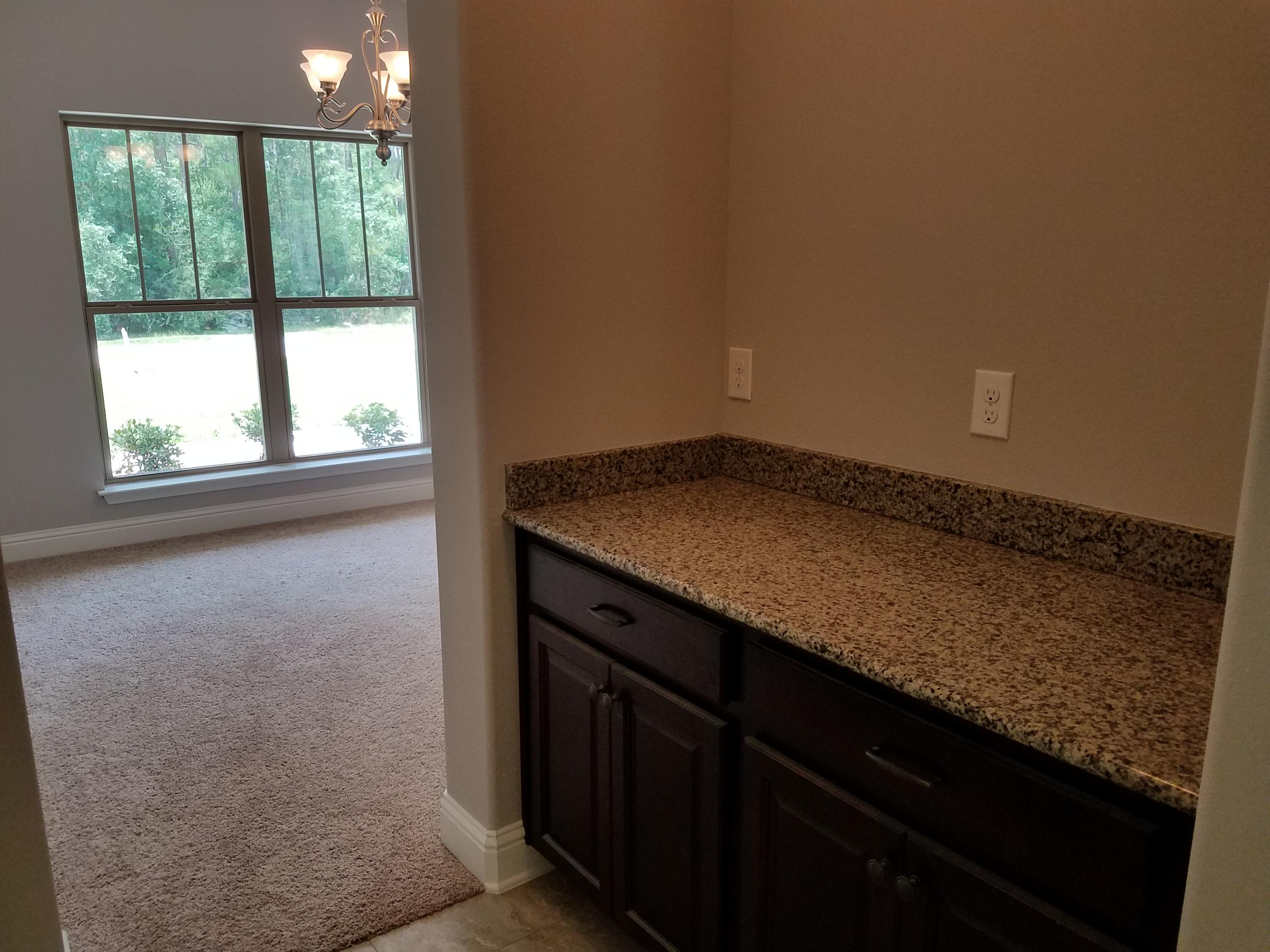 7263 Riverview Road Navarre, FL 32566 - Photo 5 of 8 a view of empty room with wooden floor and fan