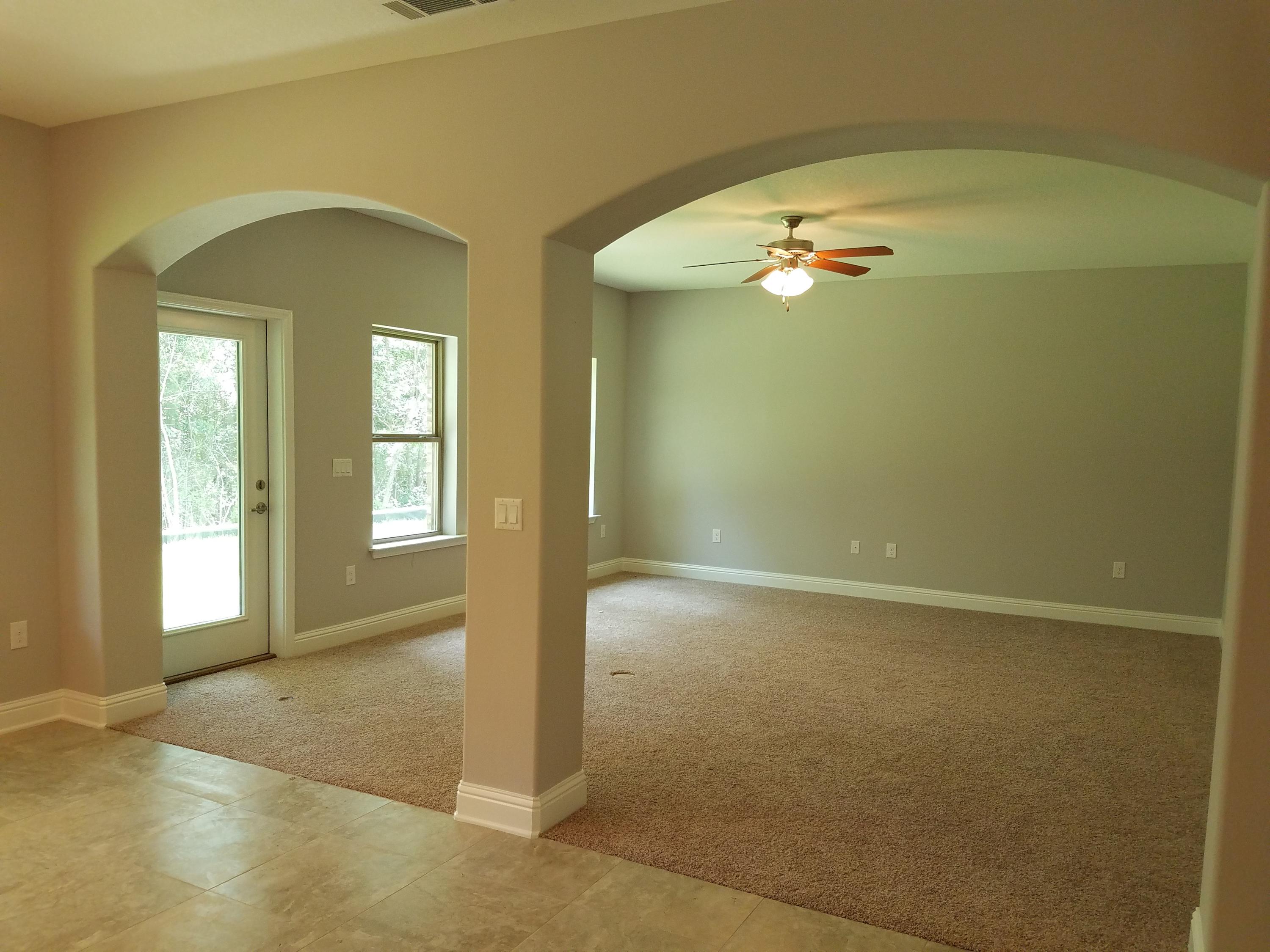 7263 Riverview Road Navarre, FL 32566 - Photo 7 of 8 an empty room with closet and a chandelier fan