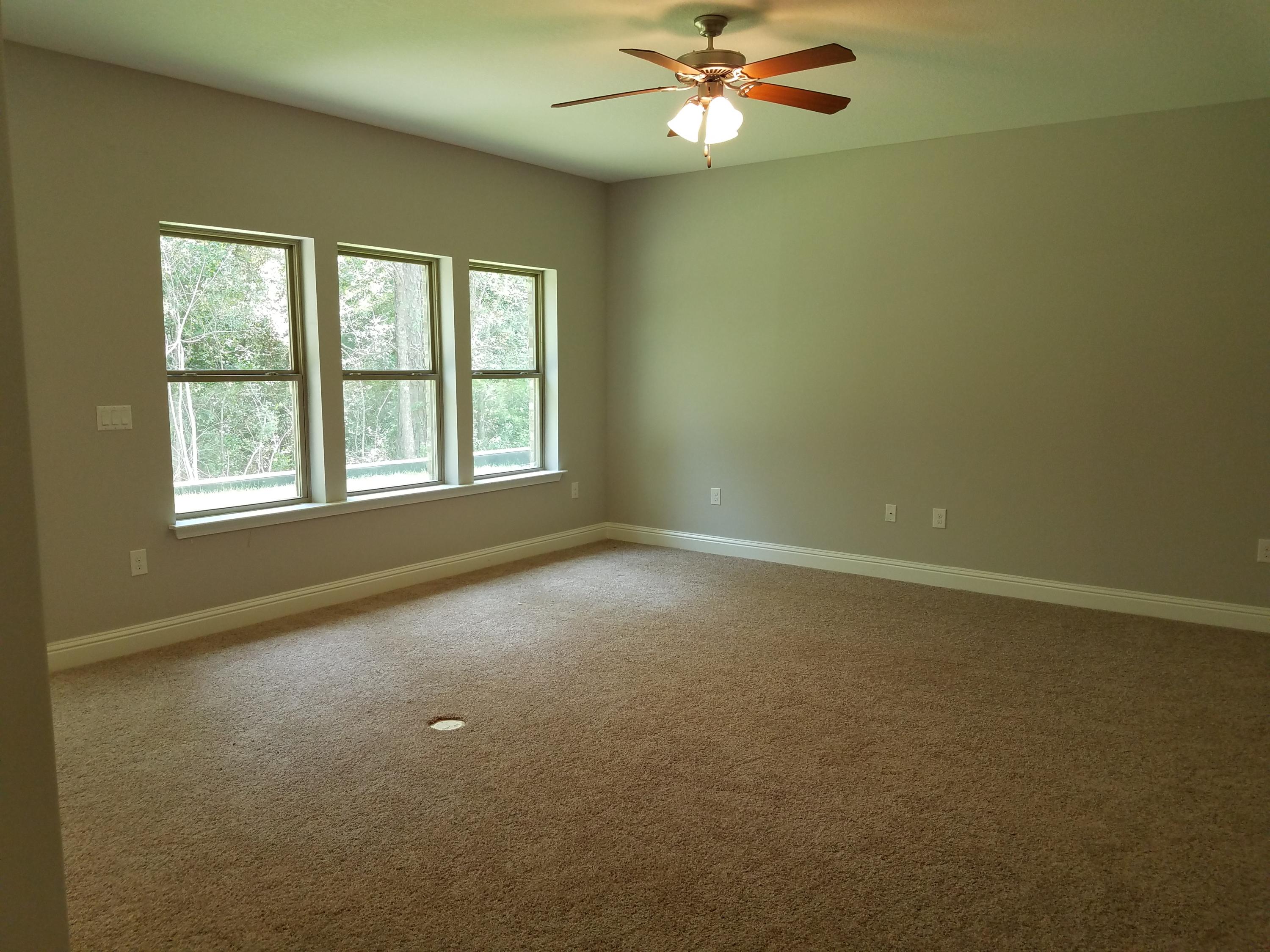 7263 Riverview Road Navarre, FL 32566 - Photo 8 of 8 an empty room with a window and a fan