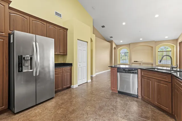 a kitchen with stainless steel appliances granite countertop a refrigerator and a sink