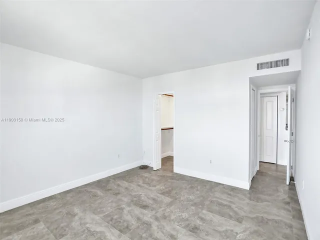 an empty room with closet and mirror