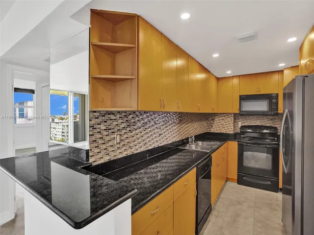 a kitchen with stainless steel appliances granite countertop a sink and a stove