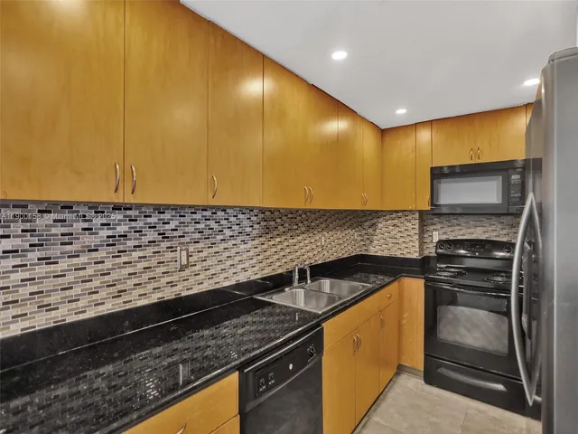 a kitchen with granite countertop cabinets and steel stainless steel appliances
