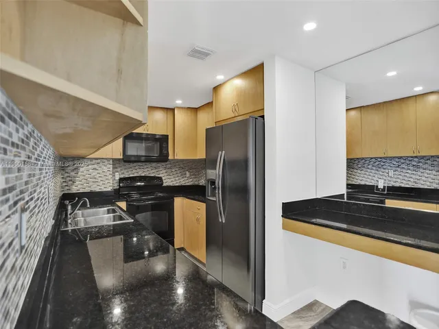 a kitchen with a refrigerator and a stove top oven