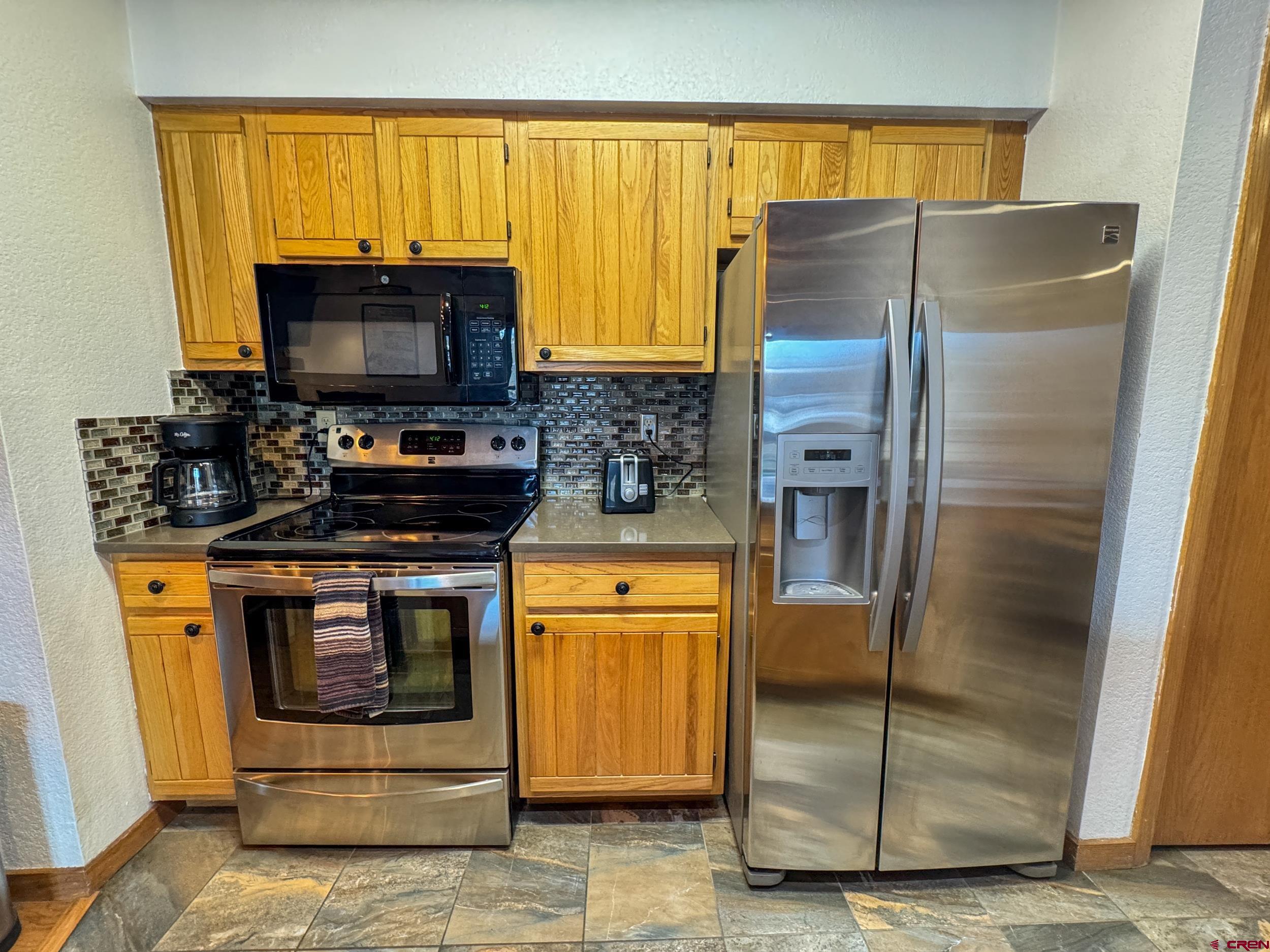 400 Gothic Road, Unit 305 Crested Butte, CO 81225 - Photo 12 of 38 a kitchen with stainless steel appliances a stove and a refrigerator