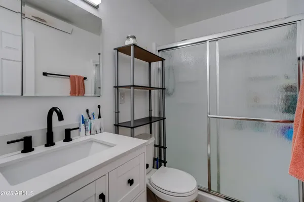 a bathroom with a sink vanity mirror and toilet