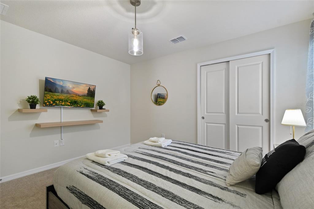 4428 Kaipo Road Davenport, FL 33897 - Photo 38 of 73 a bedroom with a bed and a flat screen tv