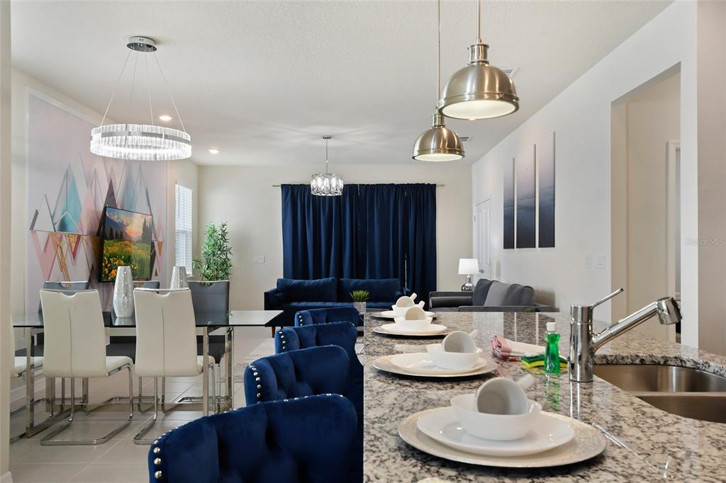 4428 Kaipo Road Davenport, FL 33897 - Photo 6 of 73 a living room with furniture a dining table and a chandelier