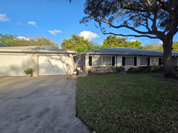 a front view of a house with a yard and lake view
