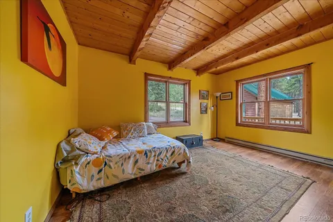 a bedroom with bed and wooden floor