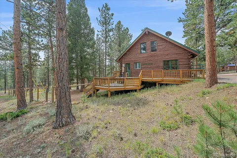 a backyard of a house with wooden fence and large trees